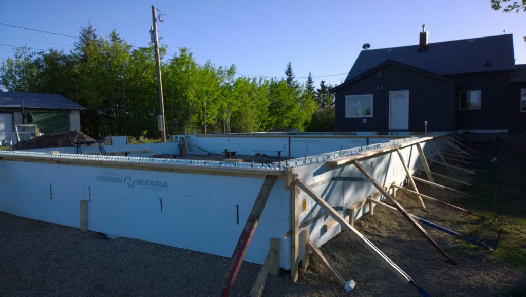 Nudura grade beam, standing at 3 feet tall, supported by screw piles, showcasing the advanced construction technology of insulated concrete forms in foundation design.
