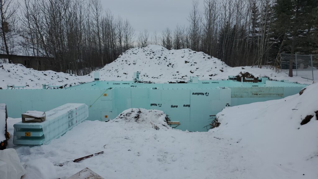 Nudura ICF basement construction in winter, showcasing insulated concrete forms for energy efficiency.