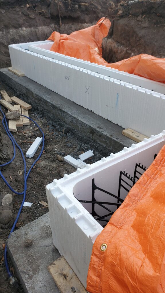 Wooden bracing securing ICF corner block in place during concrete pour