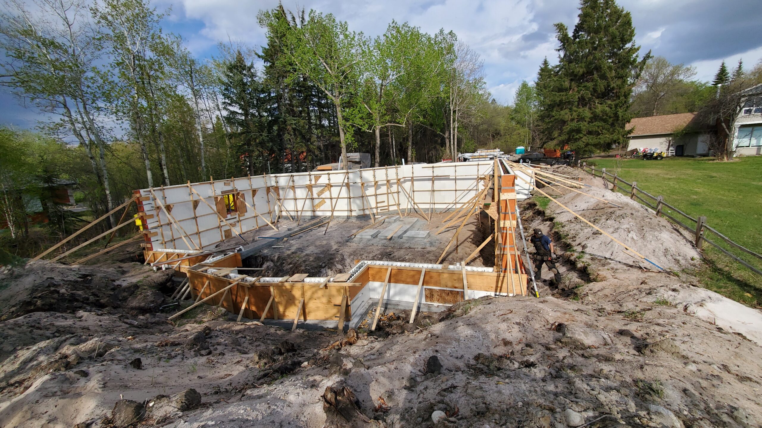 A scenic view of an Advantage ICF walk-out cabin under construction at Alberta Beach. The sturdy ICF blocks form the framework, showcasing the structural integrity before the concrete pour. The serene lakeside setting enhances the anticipation of a durable, energy-efficient retreat in the making.