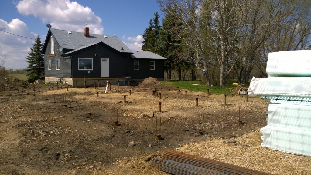 Screw piles installed for a triple car garage addition, showcasing the foundation's sturdy support for the upcoming structure that will utilize Nudura ICF blocks as the grade beam.